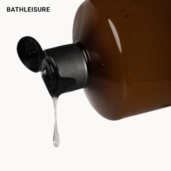 Brown bottle with black cap and liquid dripping, featuring 'BathLeisure' brand.