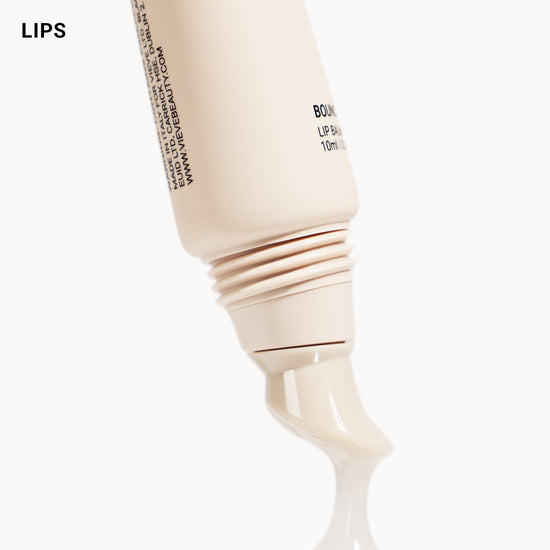 Beige lip balm tube with brand name on a white background